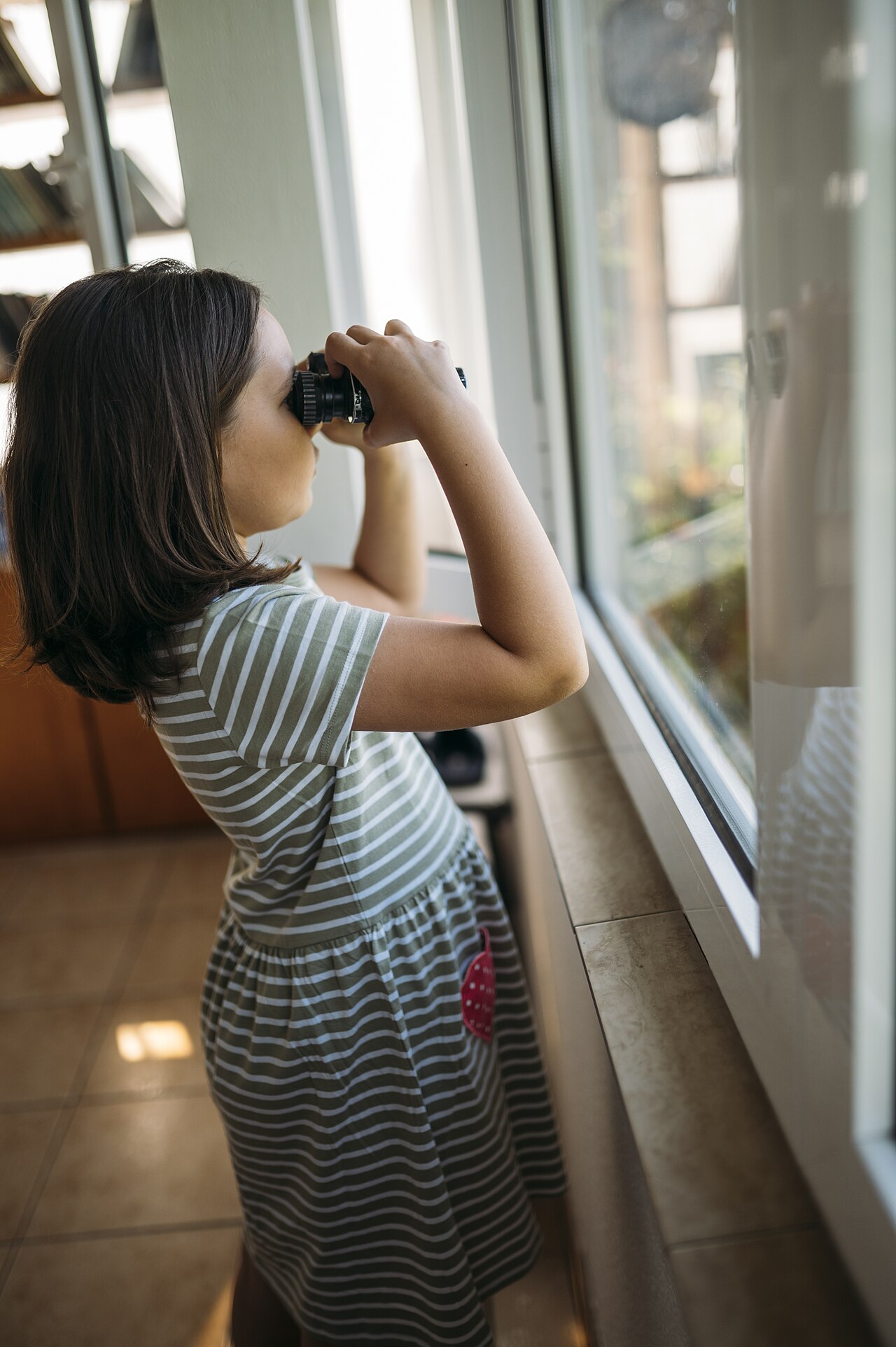 A child watching nature with binoculars